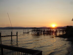 A sunset over a calm lake with wooden docks extending into the water.