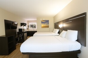 A hotel room with two beds, a TV, a desk, and a mirror. - Paragon Inn Hillsboro (Hillsboro)