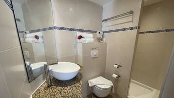 Un baño con lavamanos, inodoro y bañera blancos.