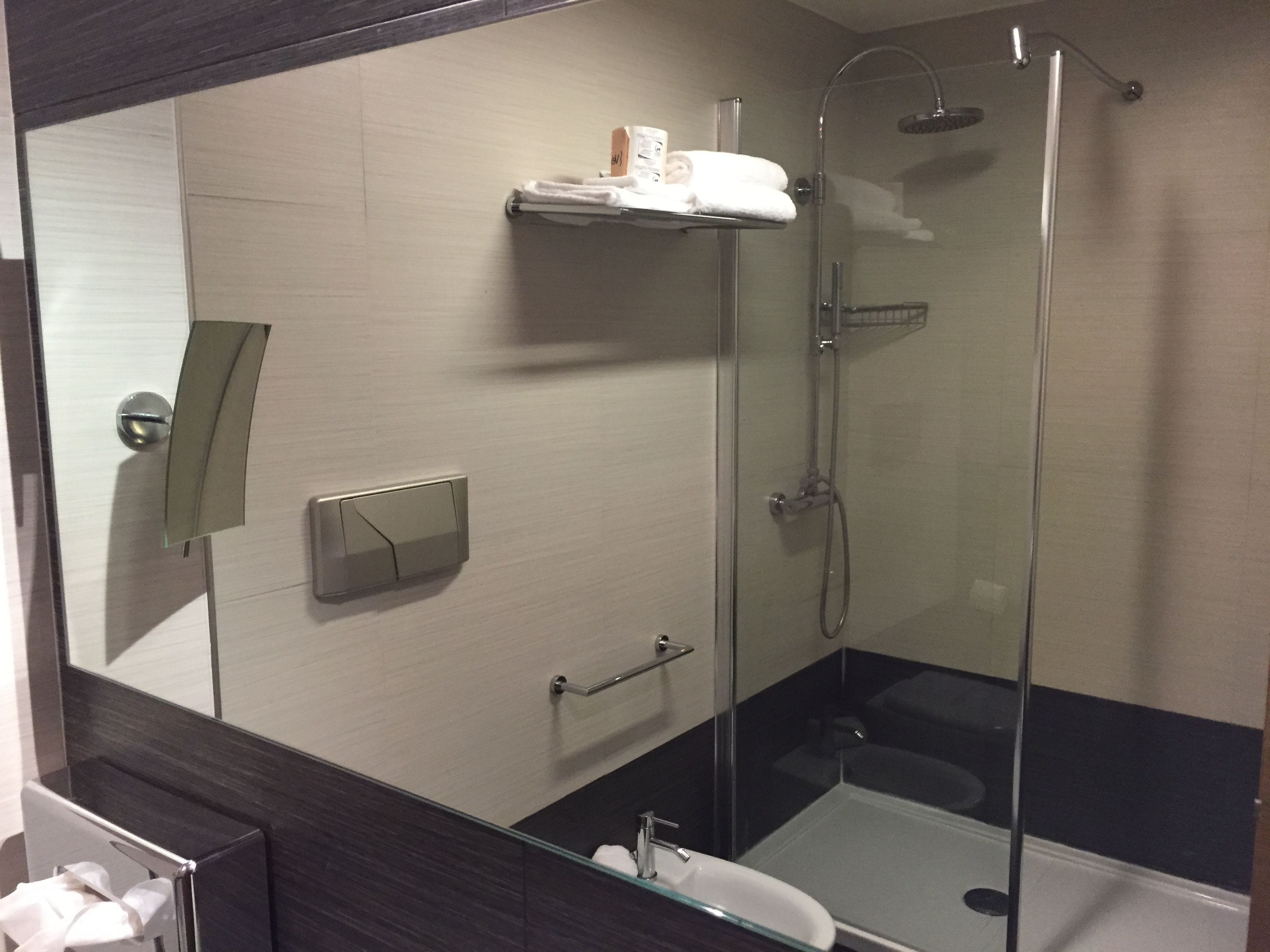 Un baño moderno con ducha de vidrio, inodoro y lavamanos.