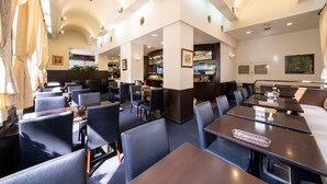 A restaurant with high tables and chairs, a kitchen area, and framed artwork on the walls. - Hotel Sunlite Shinjuku (Tokyo)