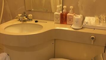 A bathroom with a sink, toilet, and toiletries.
