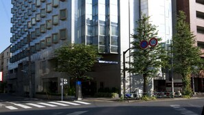 A modern building with a unique facade, large windows, and a visible sign indicating a hotel. - Hotel Sunlite Shinjuku (Tokyo)