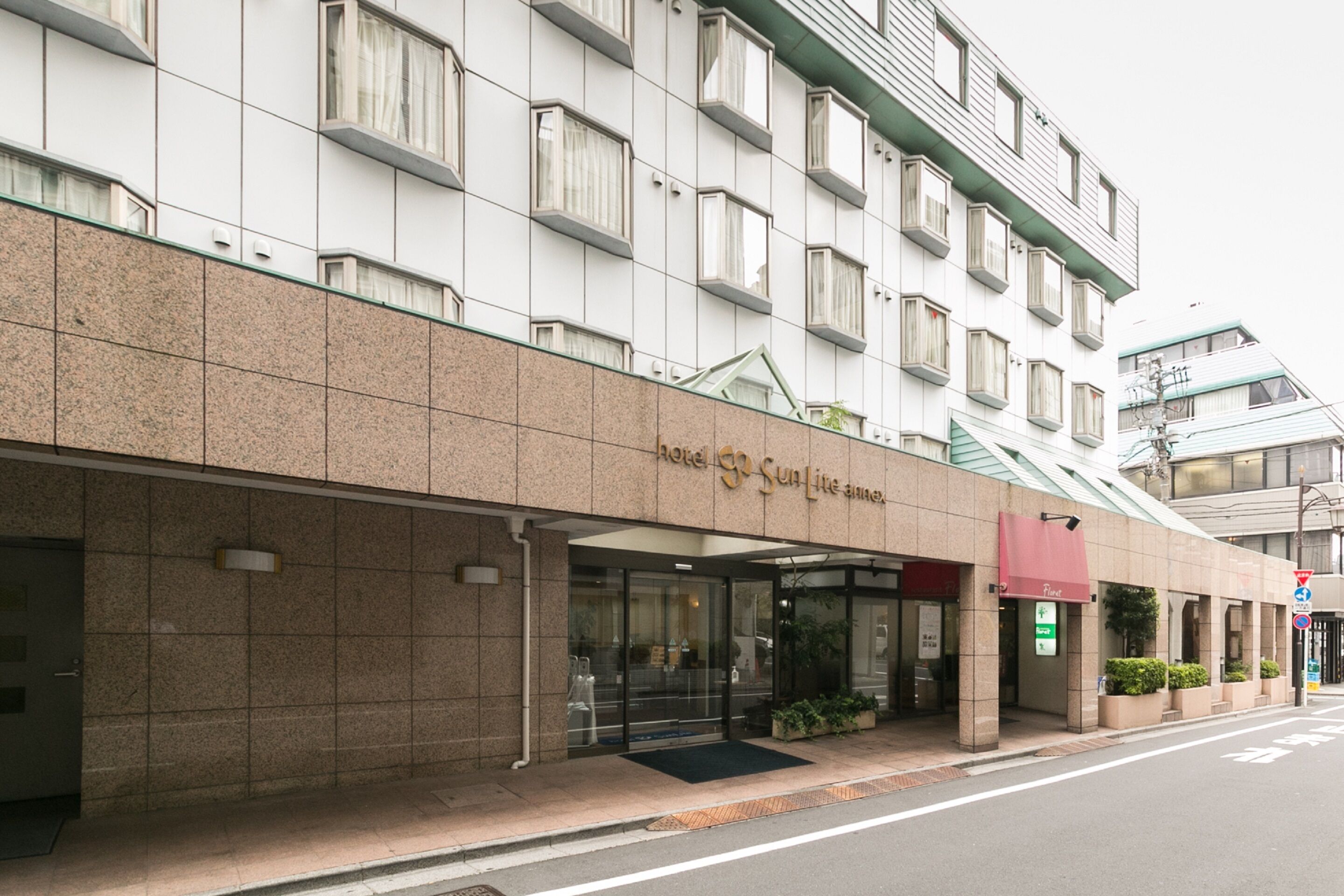 A hotel with a modern facade, large windows, and a prominent entrance with a glass door.