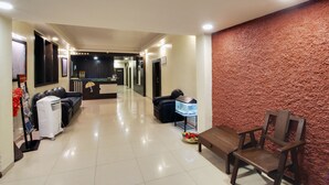 Un vestíbulo de hotel con mostrador de recepción, zona de estar y un acuario.