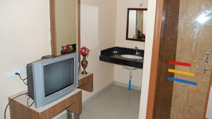 A bathroom with a television, sink, and mirror. - Hotel Utsav (Rahata)