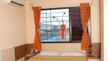 Un dormitorio con cama, cortinas, ventilador de techo y ventana con vistas.