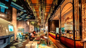 Een restaurant met een buffetopstelling, een toonbank vol eten en een decoratieve muur met ingewikkelde patronen.