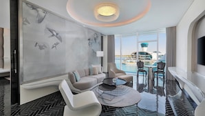 Een moderne hotelkamer met een groot raam, een zwembad en uitzicht op een toren.