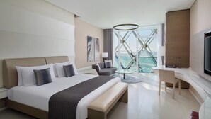 Een moderne hotelkamer met een groot bed, een bureau, een stoel en een televisie.