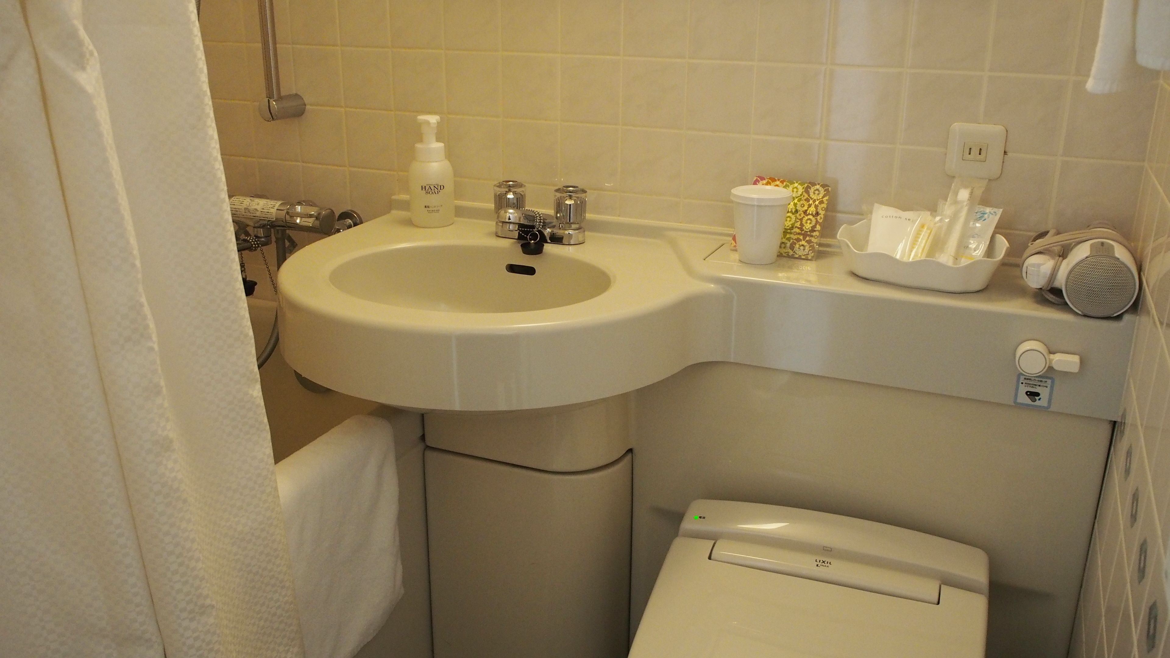 A bathroom with a sink, toilet, and shower.
