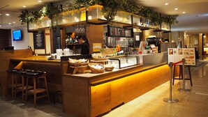 A restaurant counter with a wooden design, a menu board, and a bar area with stools. - Shibuya Tobu Hotel (Tokyo)