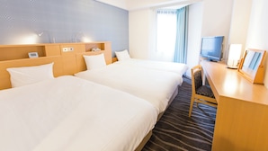 A hotel room with two beds, a desk with a TV, and a window with curtains. - Shibuya Tobu Hotel (Tokyo)