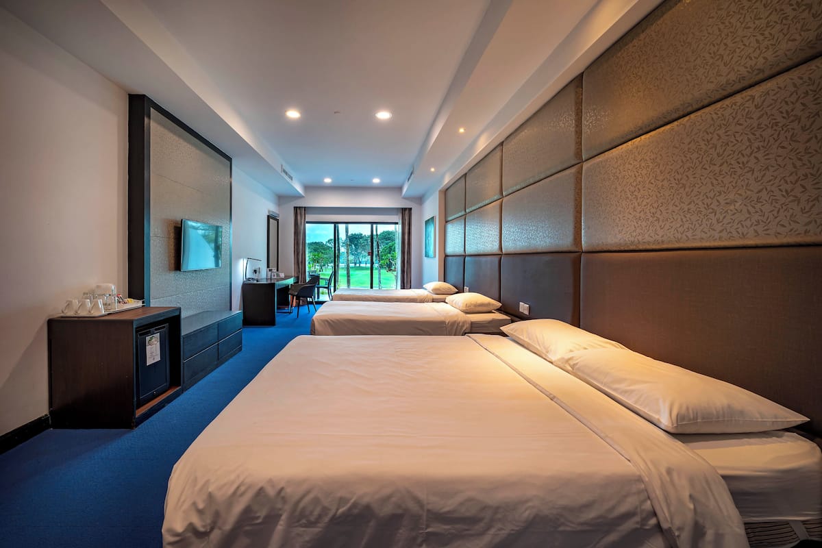 Een hotelkamer met twee bedden, een bureau en uitzicht op de omgeving.