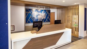 Un comptoir d’accueil au design moderne, avec une combinaison de couleurs bois et blanc.