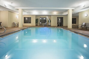 A large indoor swimming pool with a diving board, surrounded by chairs and a potted plant. - Holiday Inn Express & Suites Los Alamos Entrada Park by IHG (Los Alamos)