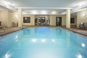 Una piscina techada, sillones reclinables de piscina