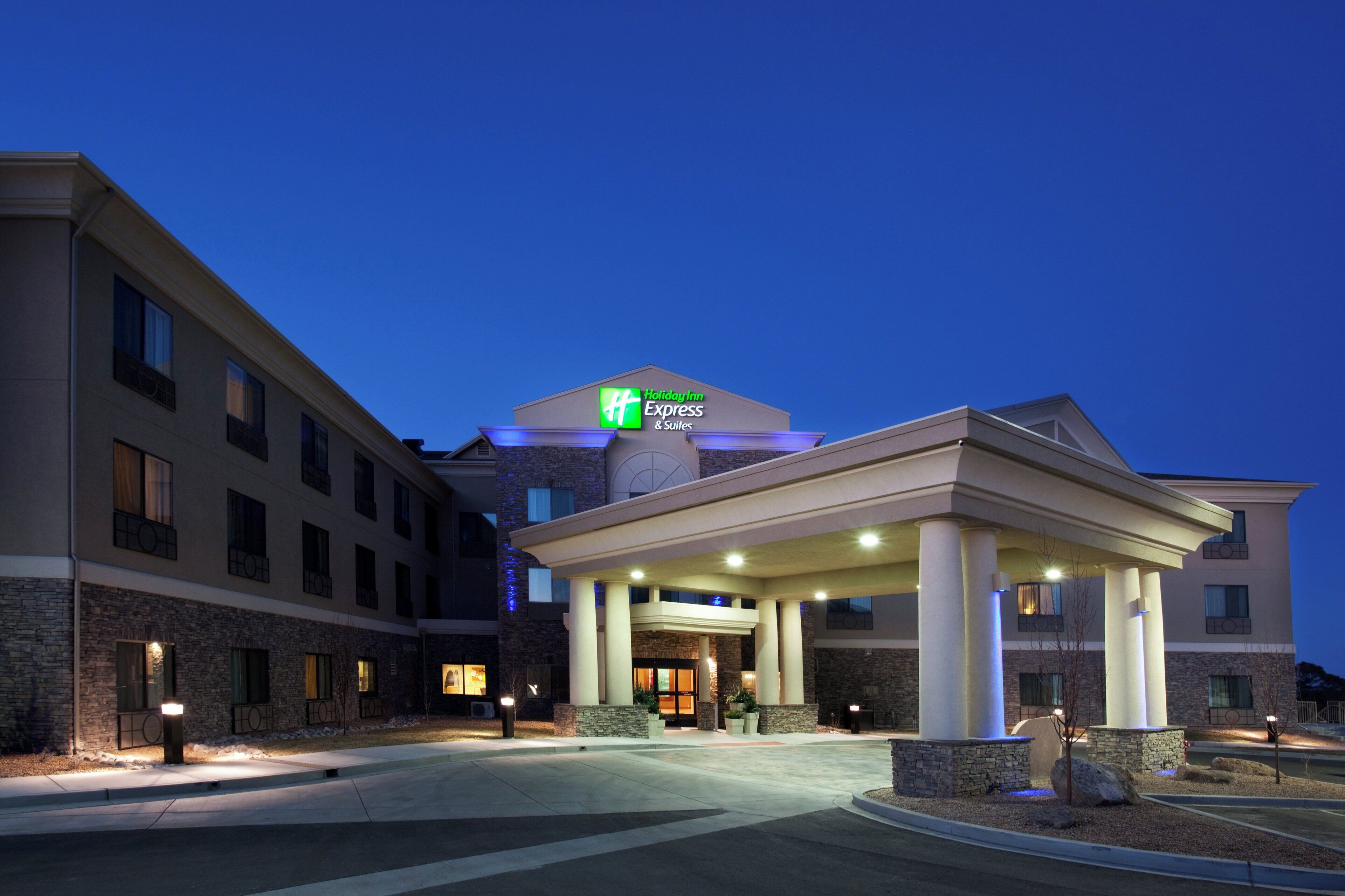 Un hotel Holiday Inn Express con entrada techada y fachada de piedra.
