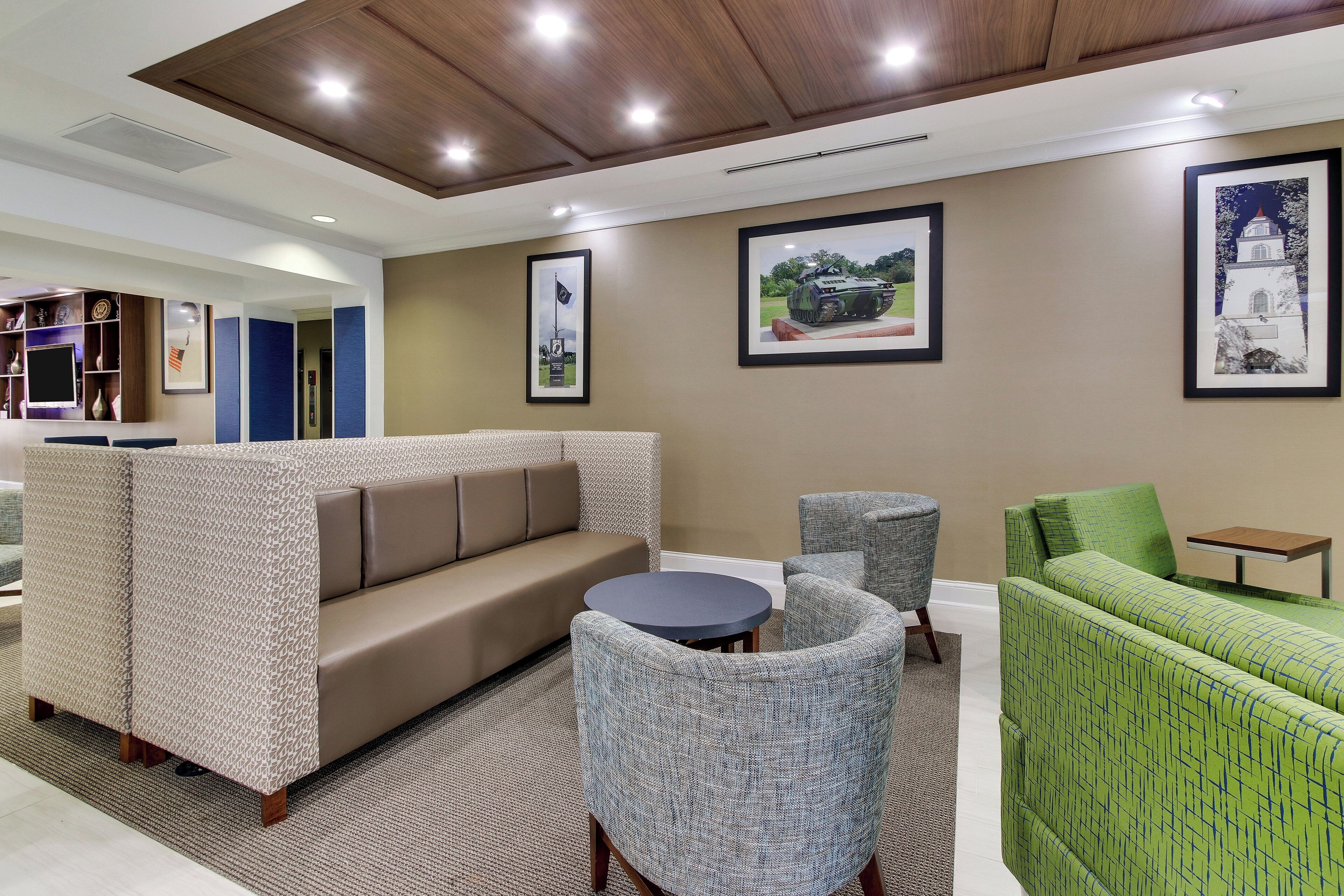 A modern lounge area with a sofa, armchairs, and a small table.