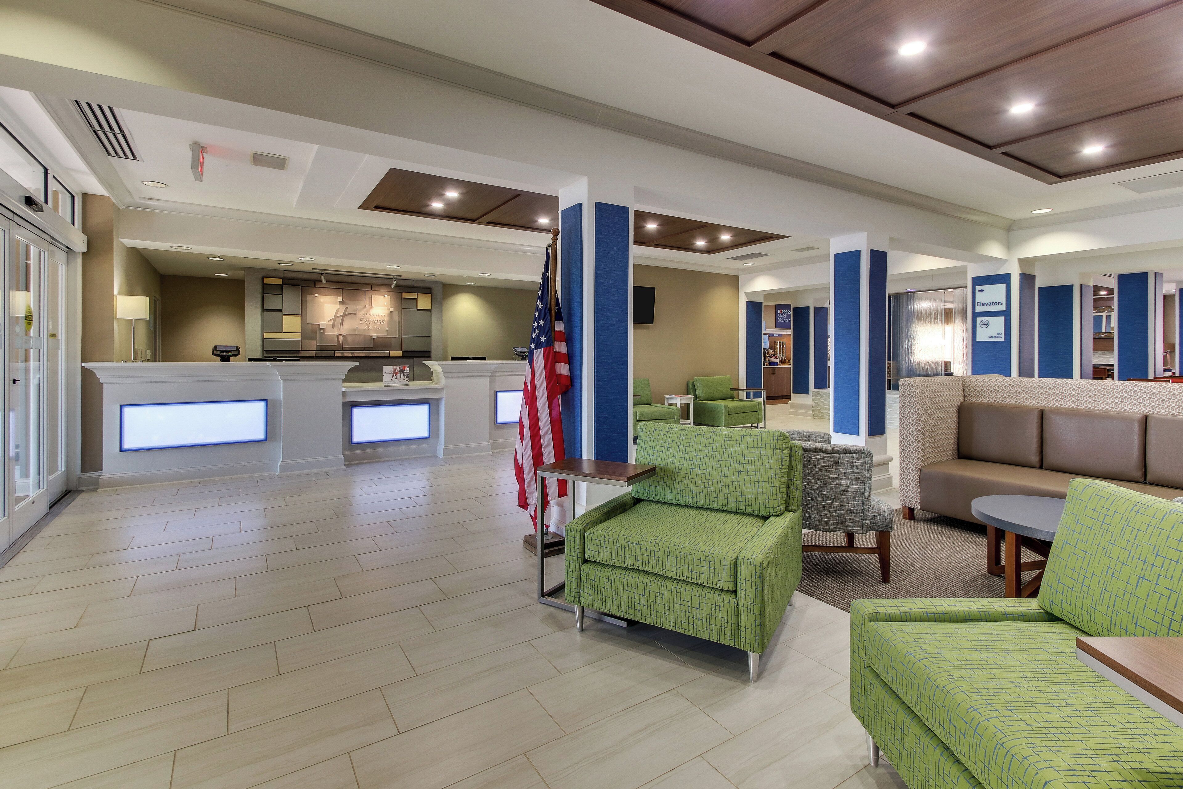 A hotel lobby with a reception desk, seating area, and a flag.