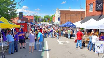 A street lined with tents and food trucks, indicating a public event or festival.