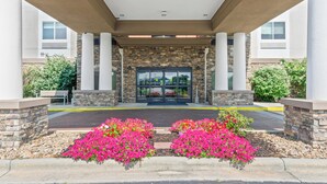 A building entrance with a stone facade, large glass doors, and a covered walkway. - Holiday Inn Express Hotel & Suites Mount Airy by IHG (Mount Airy)