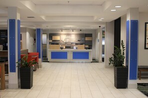 A hotel reception area with a modern design, featuring a reception desk, seating area, and a view into the hotel rooms. - Holiday Inn Express & Suites Seattle North - Lynnwood by IHG (Lynnwood)