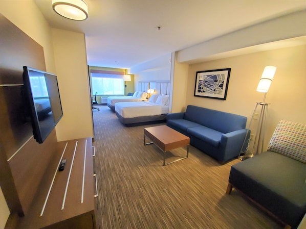 A hotel room with a TV, a sofa, a bed, a desk, and a lamp. - Holiday Inn Express & Suites Seattle North - Lynnwood by IHG (Lynnwood)