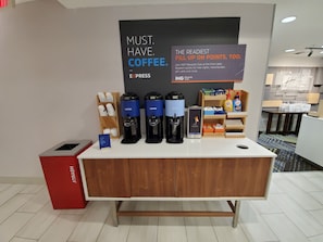 A coffee station with multiple coffee dispensers, a trash bin, and a sign promoting a rewards club. - Holiday Inn Express & Suites Seattle North - Lynnwood by IHG (Lynnwood)