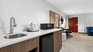 Eine moderne Küche mit Spüle, Mikrowelle und Kaffeemaschine.