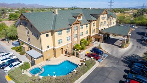 A hotel with a swimming pool, multiple parking spaces, and a view of the surrounding landscape. - Country Inn & Suites by Radisson, Tucson City Center, AZ (Tucson)