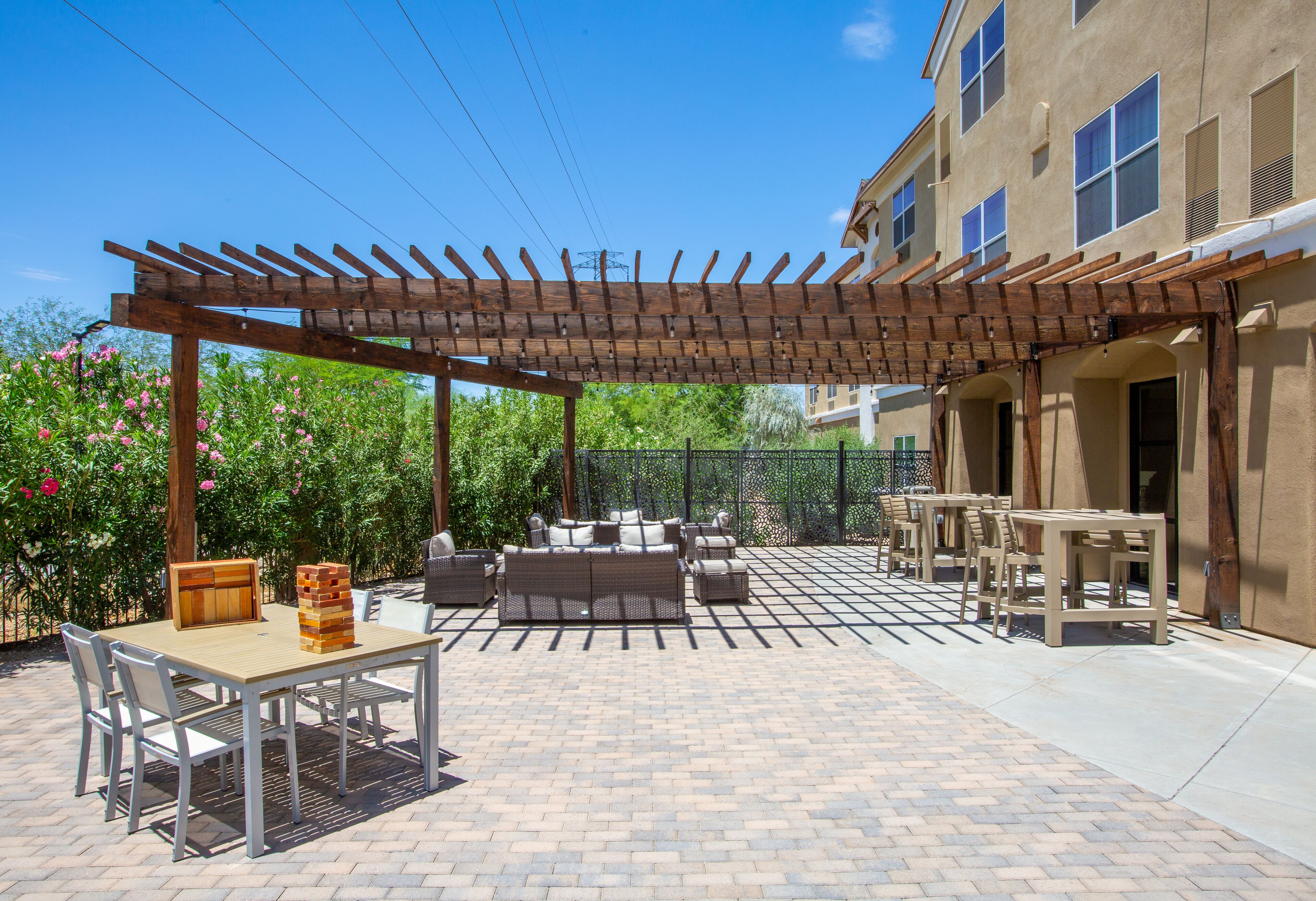 An outdoor patio area with a pergola, seating, and a table with a jigsaw puzzle.