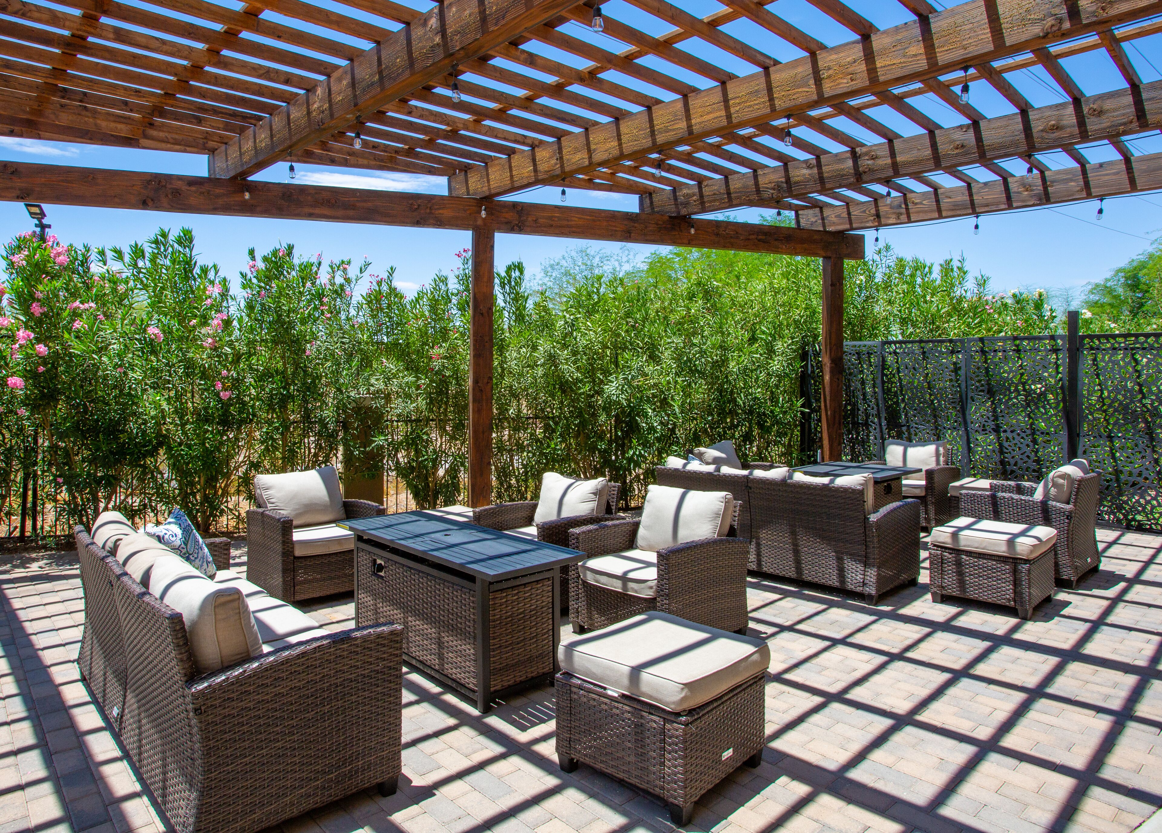 Un patio al aire libre con mobiliario de mimbre y una estructura de pérgola.