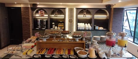 A buffet setup with various food items and beverages, including a fruit punch station.