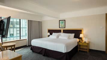 Habitación Deluxe | Edredón, minibar, caja de seguridad en la habitación y escritorio