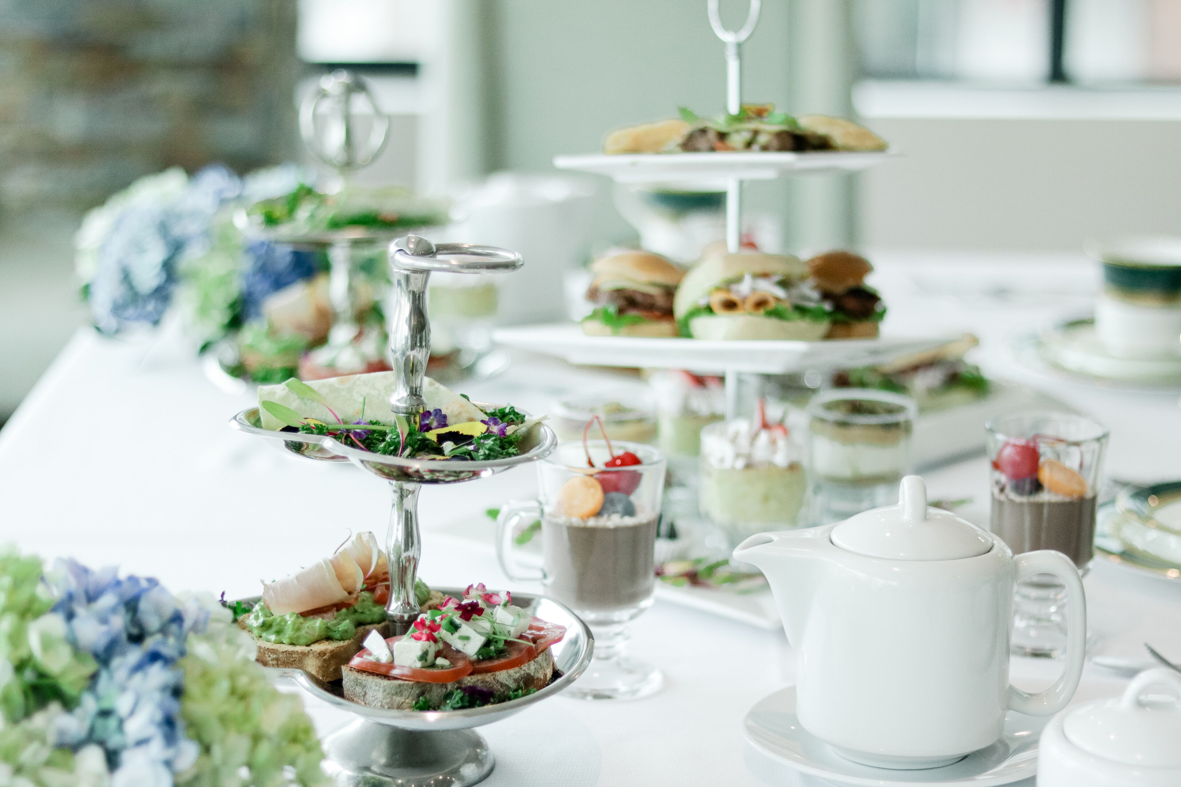 A buffet table with various food items, including sandwiches, salads, and beverages.