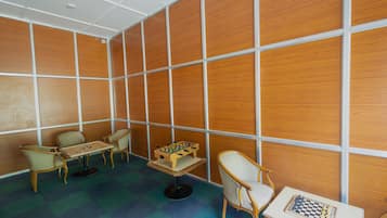 Relax in this cozy space with a foosball table, chessboard, and comfortable seating options.