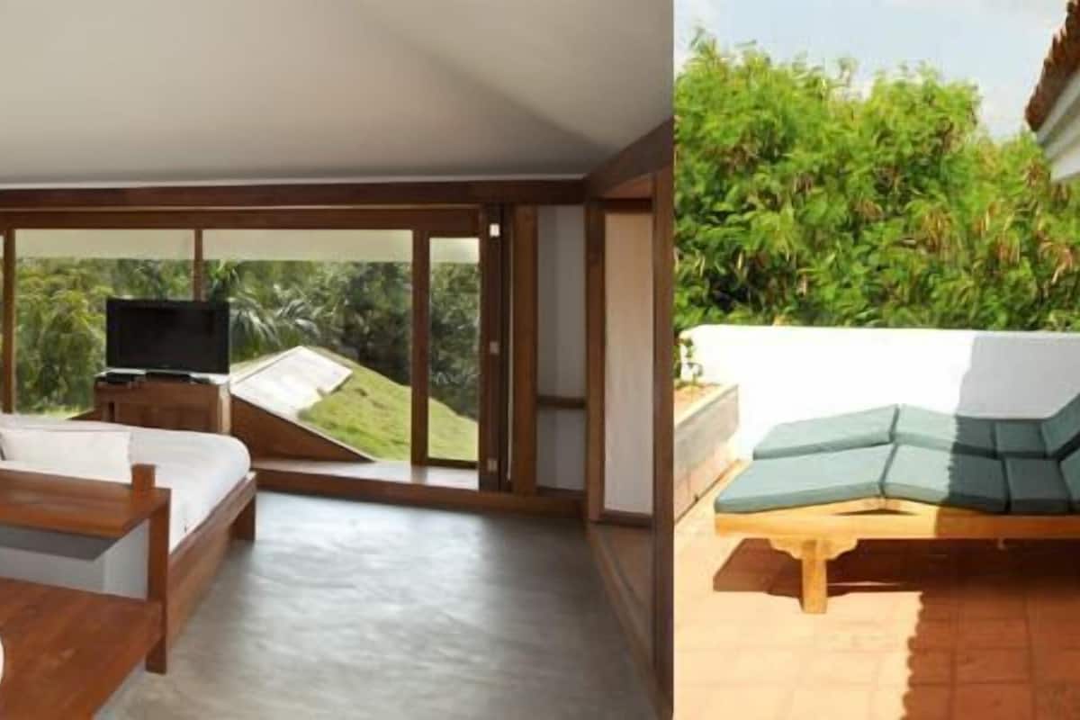 A modern room with a large window, a sofa, a TV, and a wooden floor.