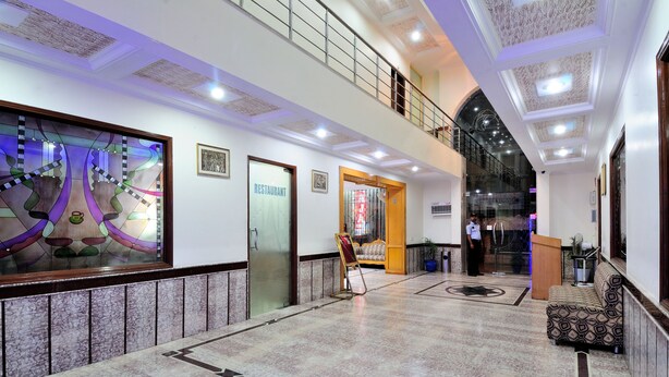 Eine großzügige Lobby mit hoher Decke, einer Treppe und einem Empfangsbereich.