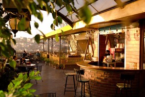 An outdoor café with a brick bar, seating, and potted plants. - Hotel Willow Banks, Mall Road Shimla (Shimla)