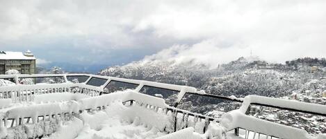 A snow-covered bridge with a view of a town in the background.