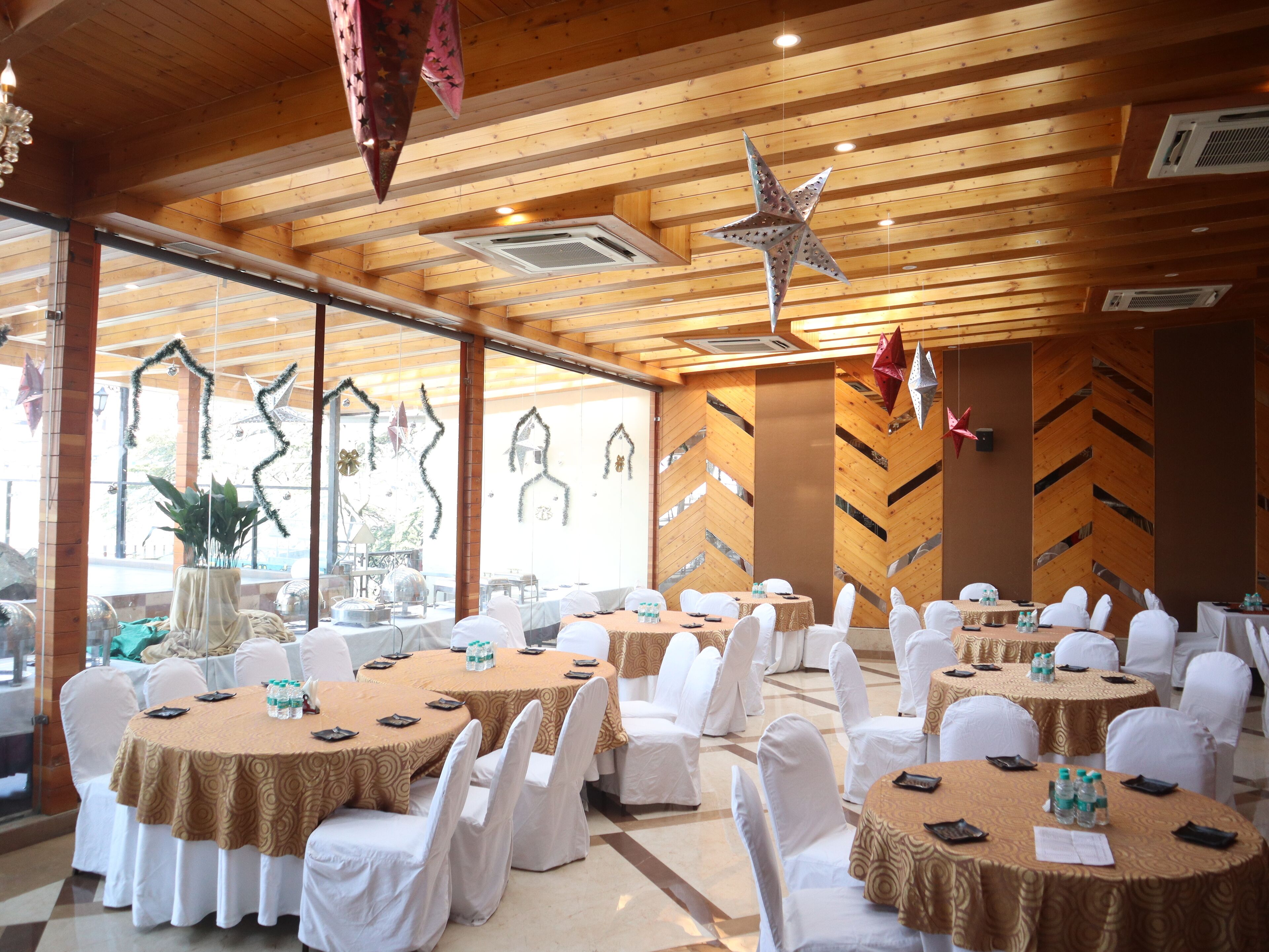 A conference room with round tables, white chairs, and a wooden ceiling.
