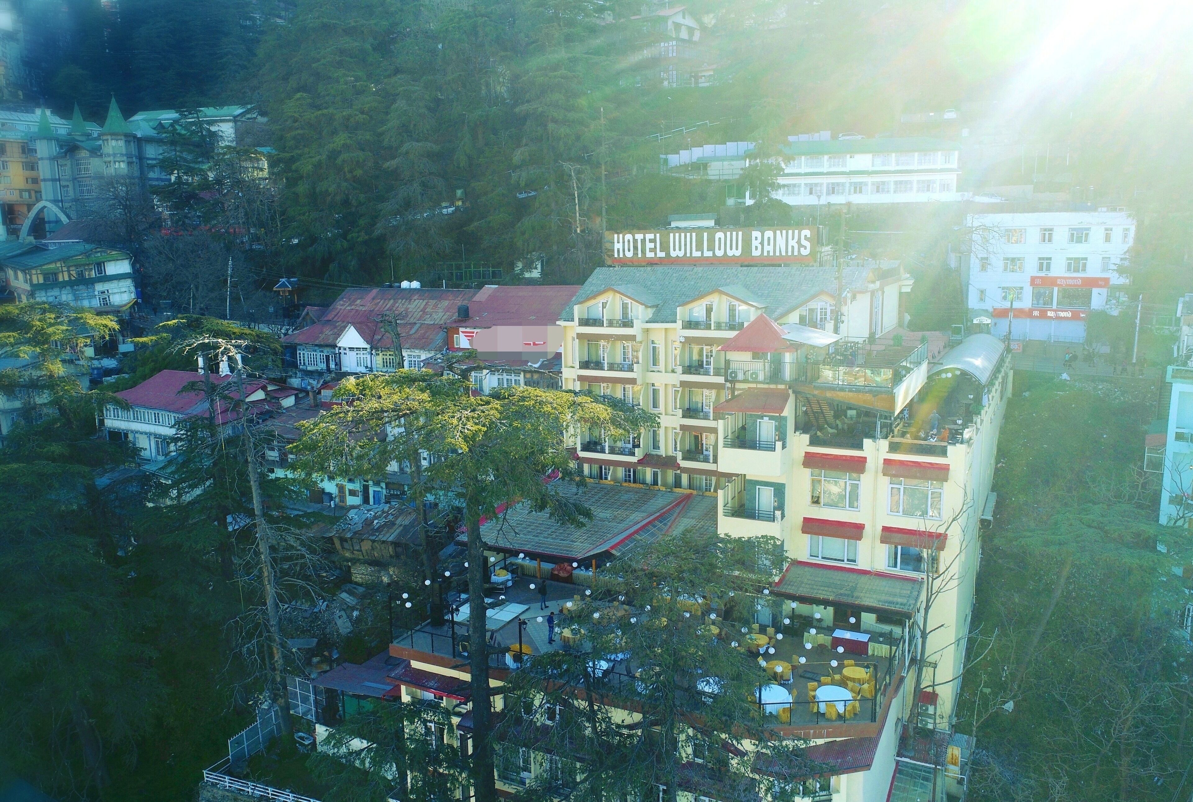 A multi-story hotel with balconies and a rooftop terrace.