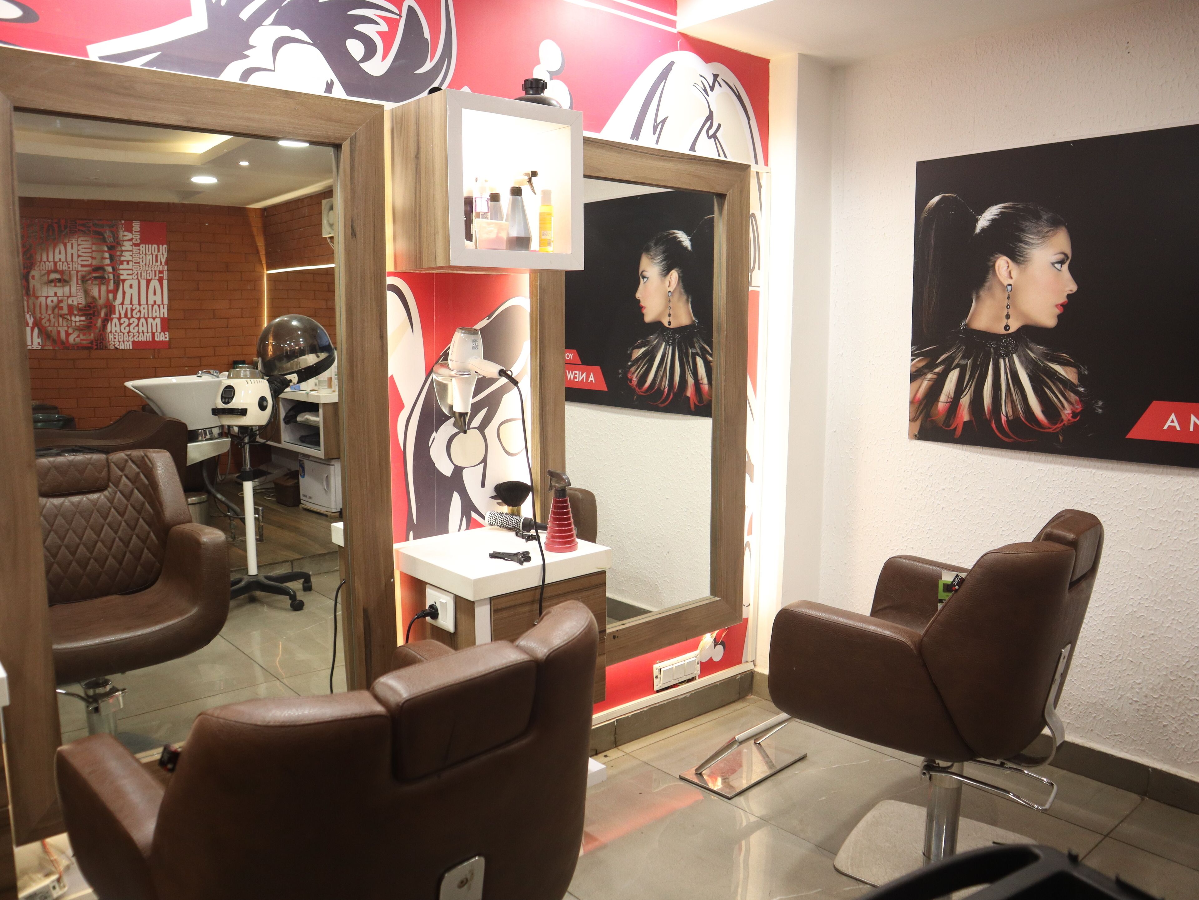 L’intérieur d’un salon avec deux fauteuils en cuir marron, un miroir et un mur orné d’une grande affiche.