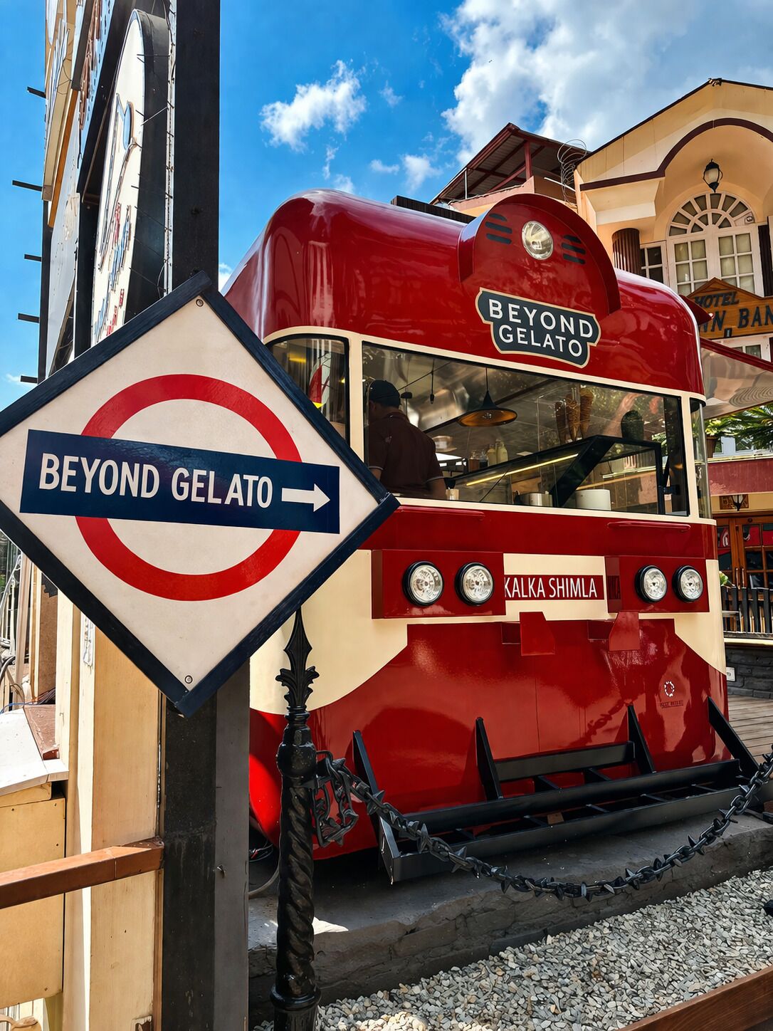 A red and white tram labeled 'Beyond Gelato' with a sign indicating 'BEYOND GELATO' and 'KALKA SHIMLA' on the side.