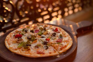 A pizza with various toppings on a wooden board.