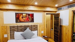 A wooden-paneled bedroom with a bed, a painting, and a wardrobe.