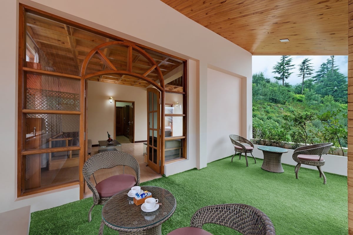 A room with a wooden ceiling, a glass door leading outside, and a small table with chairs.