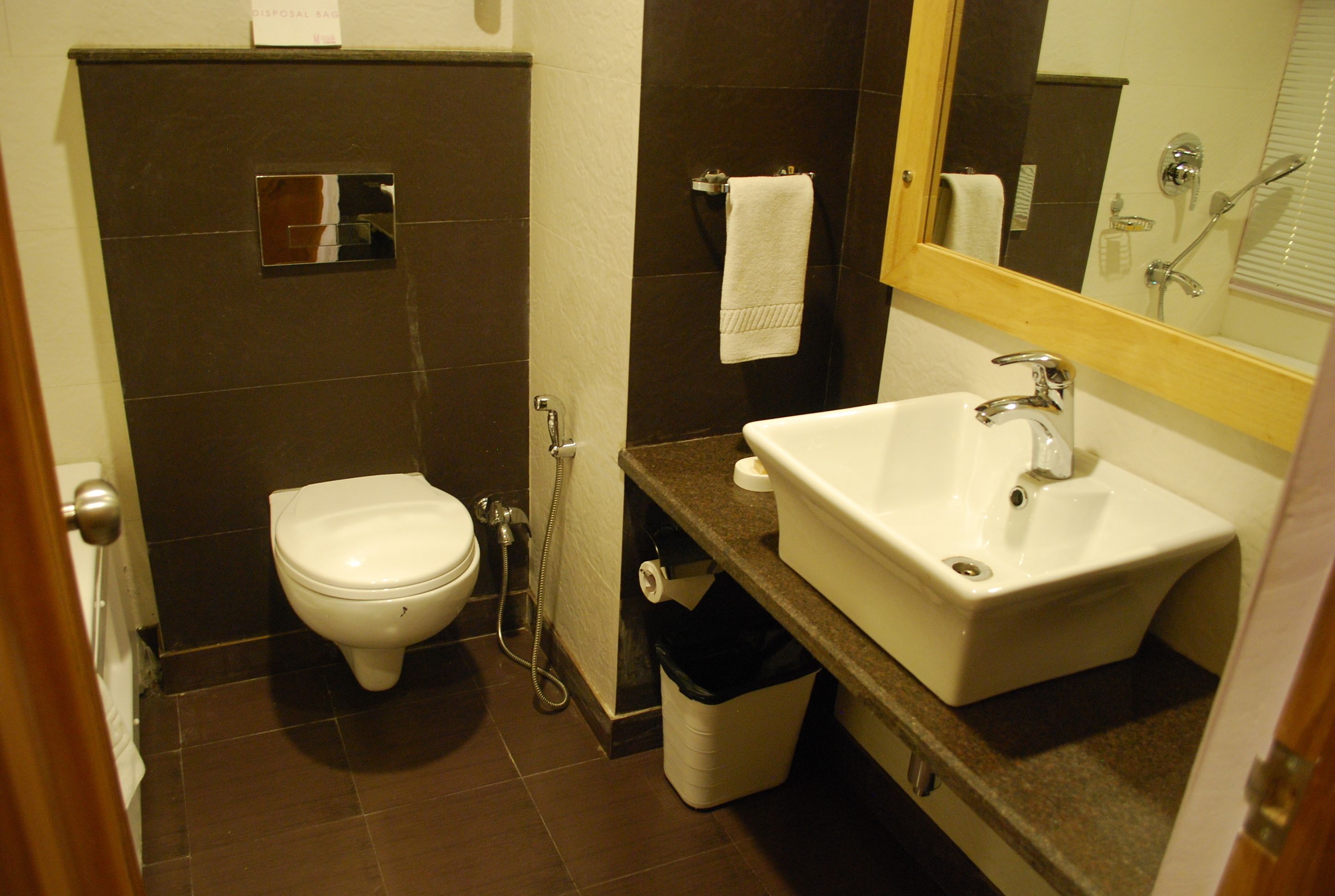 Une petite salle de bain comprenant des toilettes, un lavabo et un miroir.