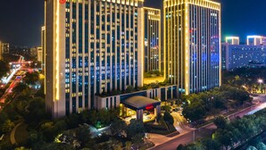 A high-rise hotel with multiple floors, a prominent entrance, and a well-lit facade.